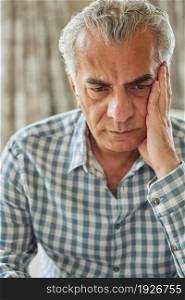 Head And Shoulders Shot Of Worried Senior Man At Home