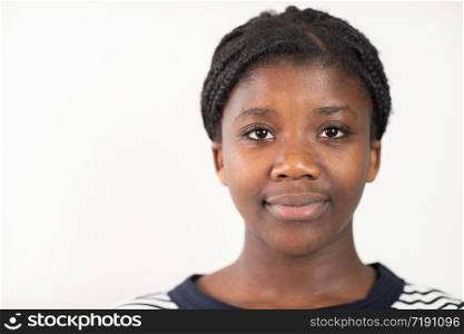 Head and Shoulders Studio Portrait Of Smiling Teenage Girl Against White Background