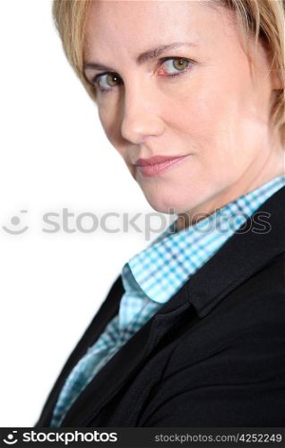 Head and shoulders studio shot of an intense woman in a suit jacket