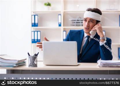 Head injured male employee working in the office 