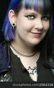 Head shot of Caucasian woman with blue hair.