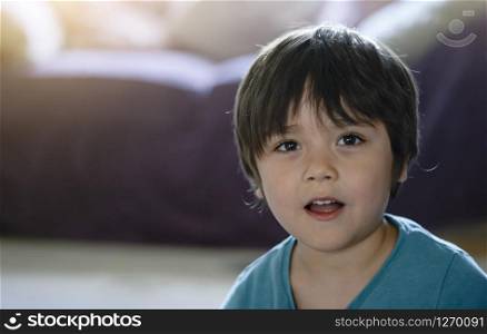Head shot of healthy kid, Portrait happy child looking at camera with smiling face, candid shot cute little boy relaxing at home. Positive children concept