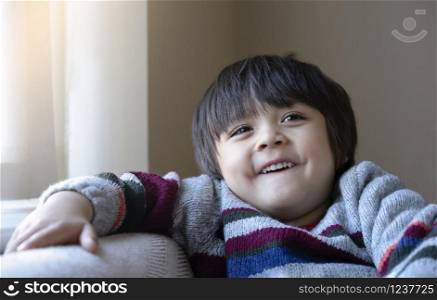 Head shot of healthy kid, Portrait happy child looking up with smiling face, candid shot cute little boy relaxing at home. Positive children concept