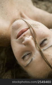 Head shot of pretty Caucasian young adult woman with eyes closed.