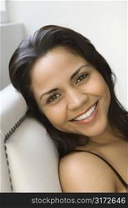 Head shot of smiling Hispanic woman looking at viewer.