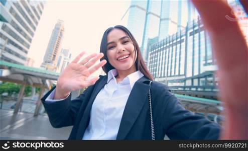 Head shot of young business woman making a video call with colleague and family outdoors, Business Lifestyle Concept. 