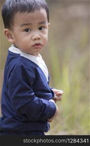 head shot portrait of asian little boy looking eyes contact to camera