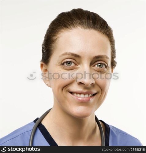 Head shot portrait of Caucasian woman doctor smiling against white background.