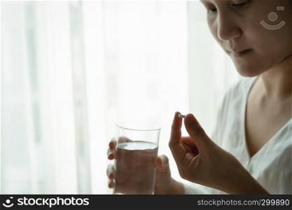 headache women hand hold medicine with a glass of water, healthcare and medicine recovery concept