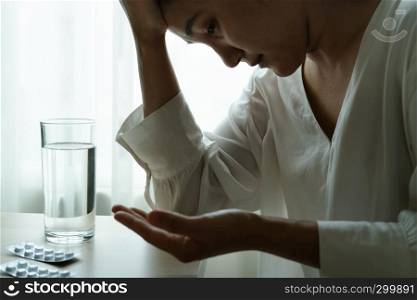 headache women hand hold medicine with a glass of water, healthcare and medicine recovery concept