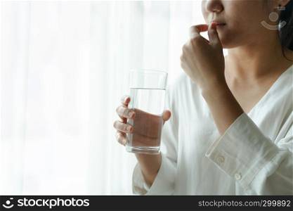headache women take medicine with a glass of water, healthcare and medicine recovery concept