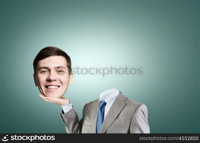 Headless businessman. Young headless businesman holding his head in palm