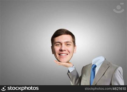 Headless businessman. Young headless businesman holding his head in palm