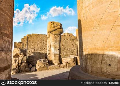 Headless statue among the ruins in Karnak Temple, Luxor. Headless statue in Karnak Temple