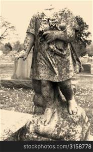 Headless stone statue in graveytard