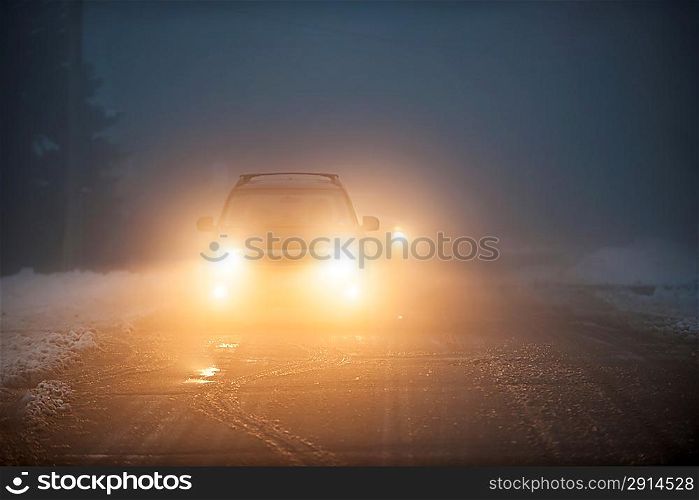 Headlights of car driving in fog