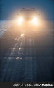 Headlights of car driving in fog