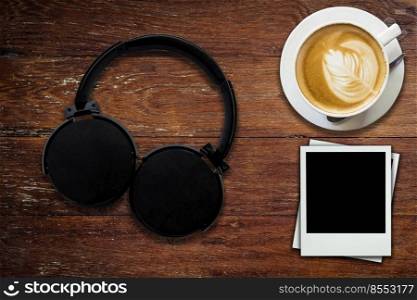 Headphone coffee and photo frame on wood background and texture