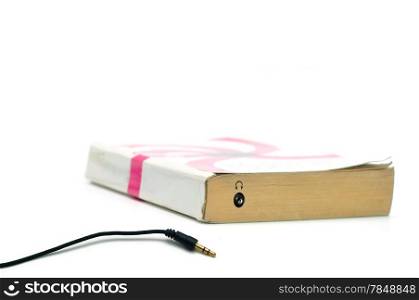 Headphones jack on book isolated on white representing audiobook concept
