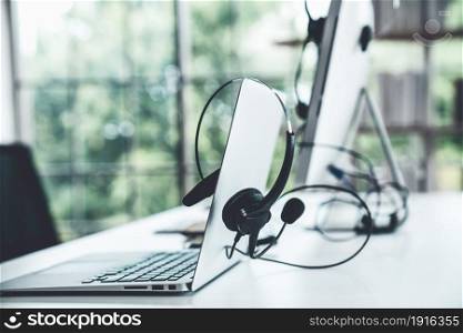 Headset and customer support equipment at call center ready for actively service . Corporate business help desk and telephone assistance concept .. Headset and customer support equipment at call center ready for actively service