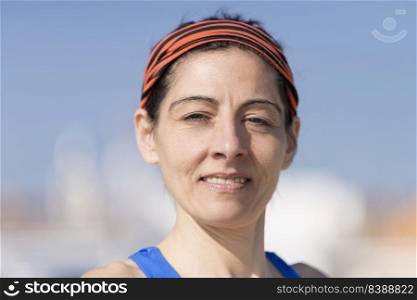 Headshot Close-up portrait of a casually runner woman smiling, Authentic people, standing alone outside on summer beach, looking camera, smiling friendly, candid photos, sunset
