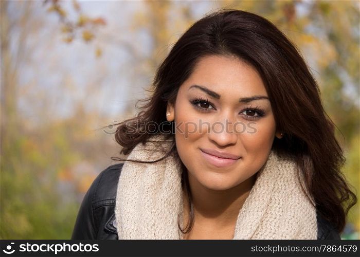 Headshot of a hispanic woman outdoors during an autumn day