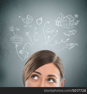 Headshot of beautiful young woman thinking. Sketches with her toughts overhead