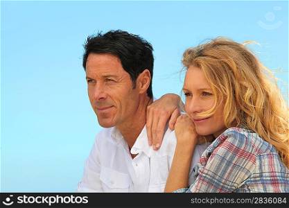 Headshot of couple with blue cloudless sky