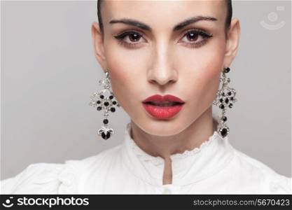 Headshot of fashionable model with perfect makeup and hairstyle. red lips, white shirt. big earrings