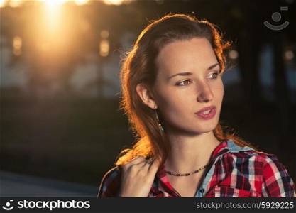 Headshot of ginger haired women backlit. Young beautiful girl at sunset
