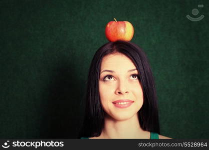 headshot of the young female with an apple on the head