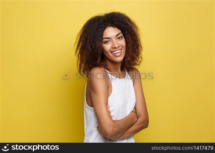 Headshot portrait of beautiful attractive African American woman posting crossed arms with happy smiling. Yellow studio background. Copy Space.. Headshot portrait of beautiful attractive African American woman posting crossed arms with happy smiling. Yellow studio background. Copy Space