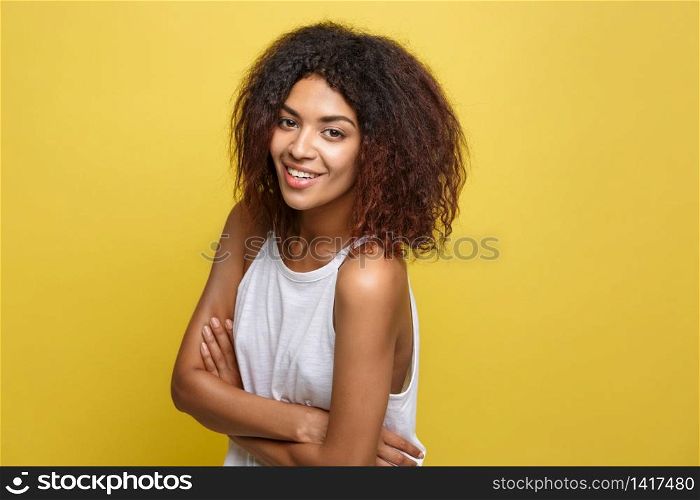 Headshot portrait of beautiful attractive African American woman posting crossed arms with happy smiling. Yellow studio background. Copy Space.. Headshot portrait of beautiful attractive African American woman posting crossed arms with happy smiling. Yellow studio background. Copy Space