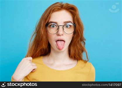 Headshot Portrait of happy ginger red hair girl with freckles smiling looking at camera. Pastel blue background. Copy Space.