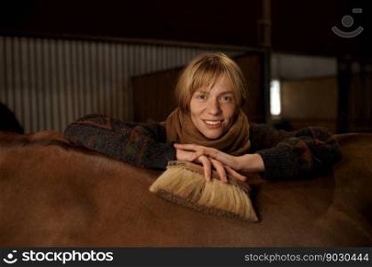 Headshot portrait of young smiling horsewoman behind horseback of her well-groomed purebred stallion. Headshot portrait of young smiling horsewoman behind horseback