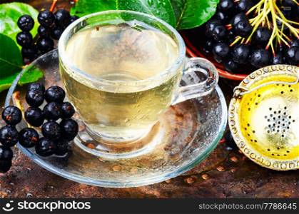 Healing aromatic tea from aronia berries. Folk medicine.. Chokeberry with leaf