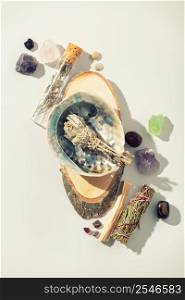 Healing crystals, palo santo, white sage bundle on abalone sea shell, dry healing herbs on white background. Relaxation and meditation kit. Witchcraft Ritual, Relaxing Chakra. Esoteric, wiccan, modern magic, life balance concept