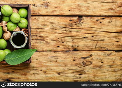 Healing drink of unripe walnut.Green walnut in herbal medicine.Copy space. Unripe walnut tincture