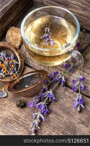 Healing, herbal tea with lavender. Herbal tea with inflorescence lavender in a glass cup in a rustic style