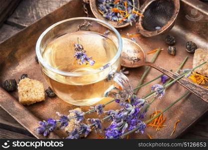 Healing, herbal tea with lavender. Herbal tea with inflorescence lavender in a glass cup in a rustic style