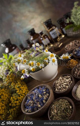Healing herbs on wooden table, mortar and herbal medicine . Fresh medicinal, healing herbs on wooden