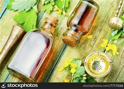 Healing tincture of celandine in a bottle.Herbal medicine.Medicinal plant celandine.. Medicinal herb celandine