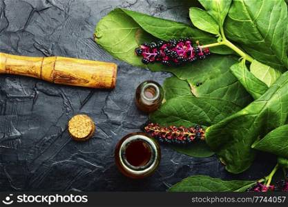 Healing tincture of lakonos,herbal medicine.Wild plant,pokeberry.Top view. Inflorescence phytolacca in herbal medicine