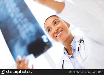healt and medicine concept - smiling female doctor studying x-ray