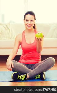 healt, dieting, home and happiness concept - smiling sporty teenage girl with green apple at home