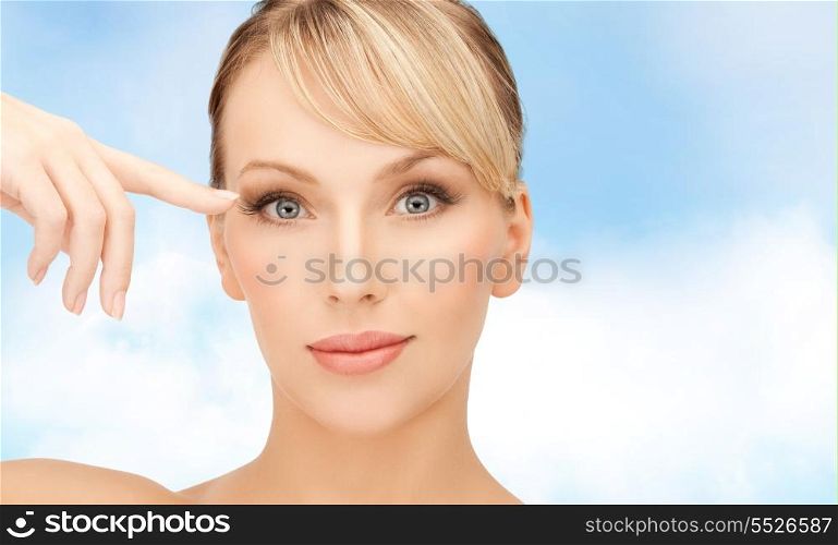 healt, spa and beauty concept - face of beautiful woman touching her eye area