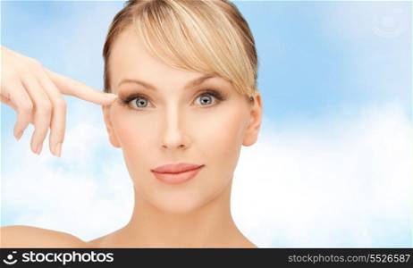 healt, spa and beauty concept - face of beautiful woman touching her eye area
