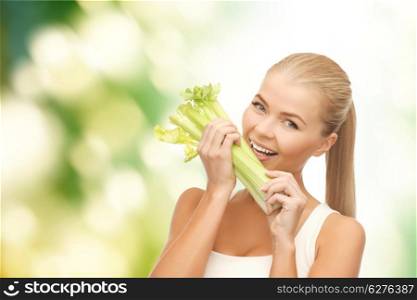 healtcare, food and diet concept - smiling woman biting piece of celery or green salad