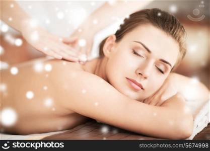 health and beauty concept - beautiful woman in spa salon getting massage