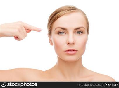 health and beauty concept - beautiful woman pointing at her face